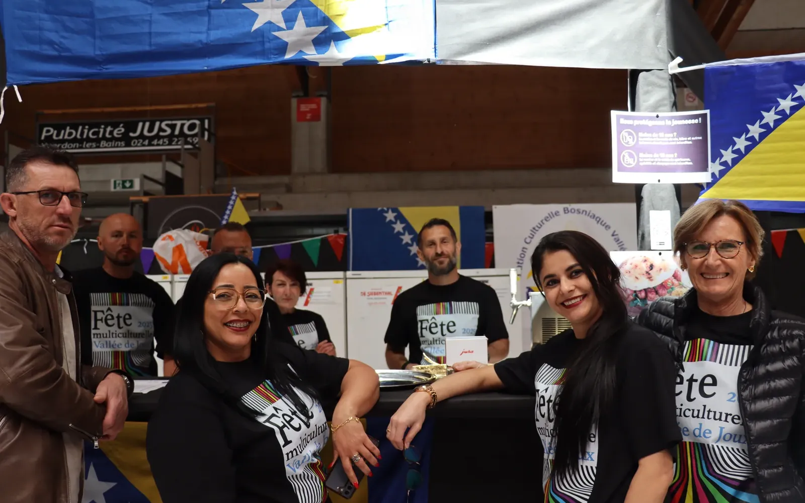 Groupe réuni devant un stand décoré de drapeaux de la Bosnie-Herzégovine